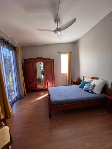 1 dormitorio con 1 cama y ventilador de techo en L'oasis de L'Entre-Deux, en Entre-Deux