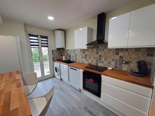 une cuisine avec des armoires blanches et un plancher en bois dans l'établissement Appartement A Beholding Sight, à Amélie-les-Bains-Palalda