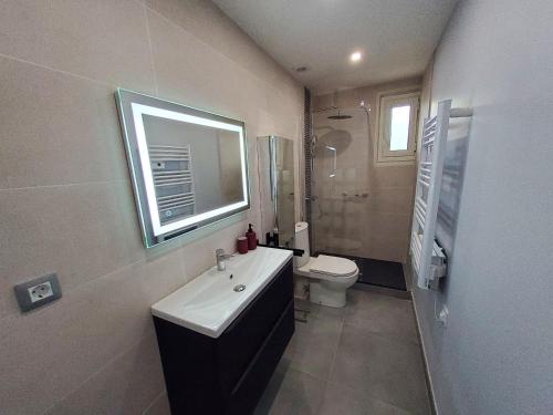 a bathroom with a sink and a toilet and a mirror at Appartement A Beholding Sight in Amélie-les-Bains-Palalda