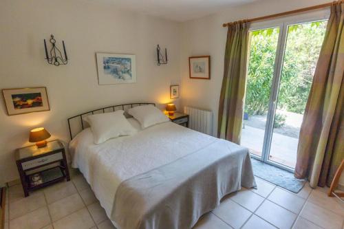 une chambre avec un lit et une porte coulissante en verre dans l'établissement Azur Blue Villa; Rural Peace with private pool, à Peymeinade