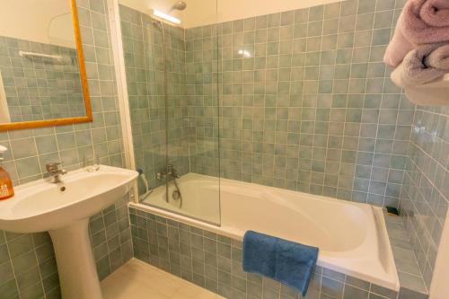 La salle de bains carrelée de couleur verte est pourvue d'un lavabo et d'une baignoire. dans l'établissement Azur Blue Villa; Rural Peace with private pool, à Peymeinade