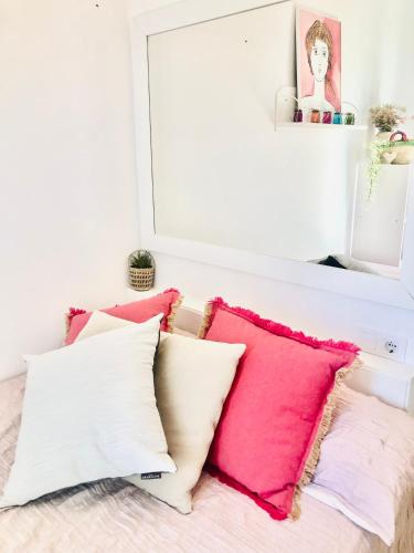 a row of pillows on a bed with a mirror at Precioso piso en el centro neurálgico de Olot in Olot
