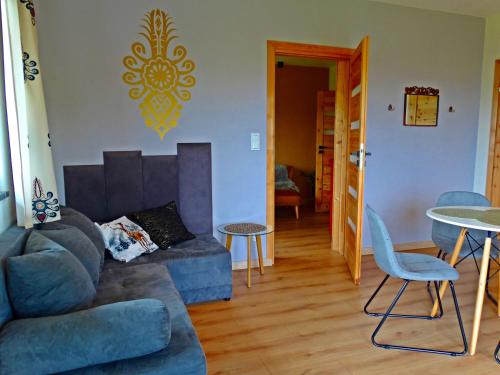 ein Wohnzimmer mit einem Sofa und einem Tisch in der Unterkunft Apartamenty Widokówka in Grywałd