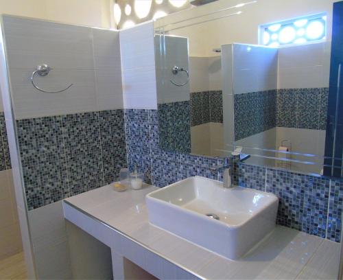 bagno con lavandino e specchio di WouroBa a Mbodiène