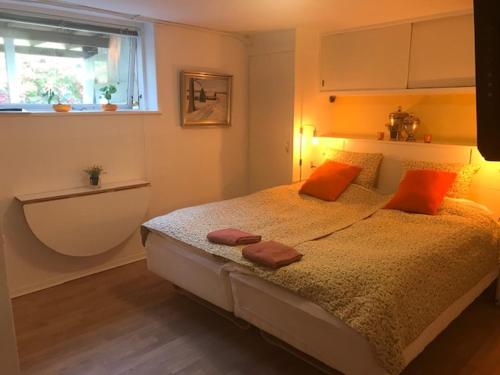een slaapkamer met een bed met oranje kussens en een raam bij Spangsbo b&b in Randers