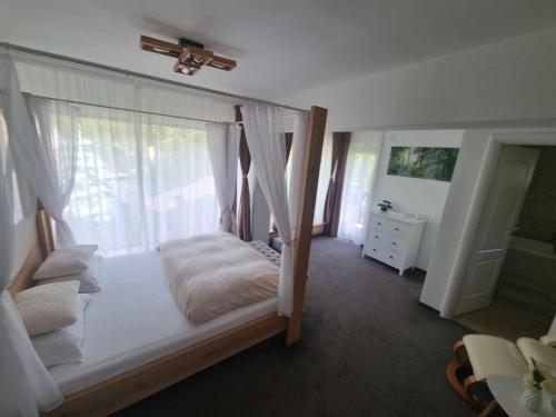 a bedroom with a canopy bed with a window at Pensiunea Anotimpuri by Casa Sandu in Bran