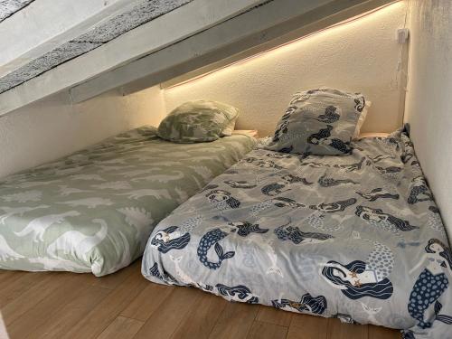 deux lits côte à côte dans une pièce dans l'établissement Studio les pieds dans l eau au Brusc 4 personnes, à Six-Fours-les-Plages