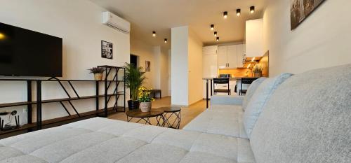 un salon avec un canapé blanc et une cuisine dans l'établissement 2 room Apartment, new building, Bosákova street, 49, à Bratislava