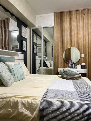 ein Schlafzimmer mit einem großen Bett und einem Spiegel in der Unterkunft Luxury Suite in Araneta in Manila