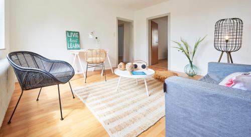 a living room with a blue couch and chairs at interaktiv . Appartements in Heiligenhaus
