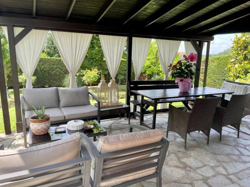eine Terrasse mit einem Sofa, einem Tisch und Stühlen in der Unterkunft Suite Villa Aurelj in Barolo