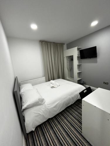 a hotel room with a bed and a television at 339 High Town Road in Luton