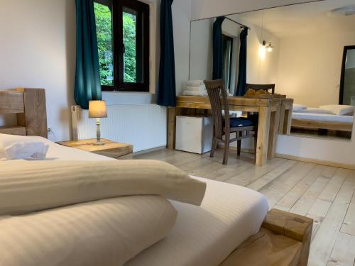 a bedroom with two beds and a table and a desk at Pensiunea Poiana Izvoarelor in Vatra Dornei