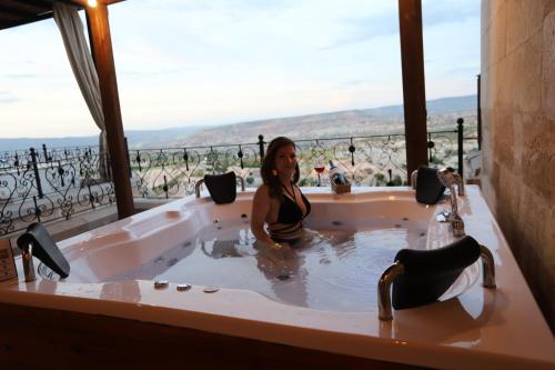 a woman is sitting in a bath tub at Simera in Cappadocia - Special Class - Best View Rooftop in Uchisar