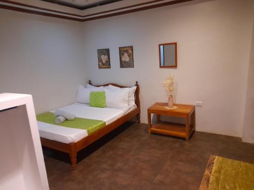ein kleines Schlafzimmer mit einem Bett und einem Tisch in der Unterkunft MilVir Tourist INN in El Nido
