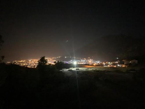 a view of a city at night with lights at house naim in Chefchaouen