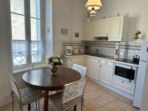 a kitchen with a table and a table and chairs at Charmant T2 saint Enogat in Dinard