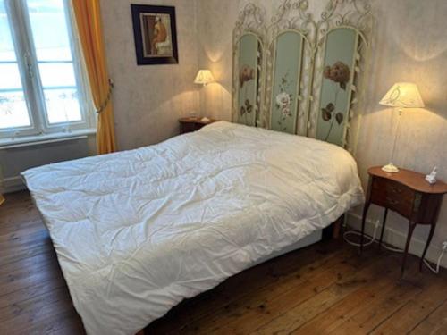 sypialnia z dużym białym łóżkiem z dwoma stołami w obiekcie Charmant T2 saint Enogat w mieście Dinard