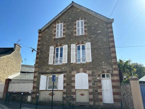 a brick building with white doors and windows at Charmant T2 saint Enogat in Dinard