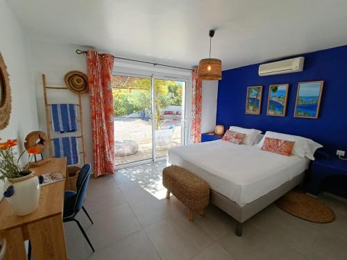 une chambre avec un lit et un mur bleu dans l'établissement VILLA BAUHINIA - Golfe de Saint-Tropez, au Plan-de-la-Tour