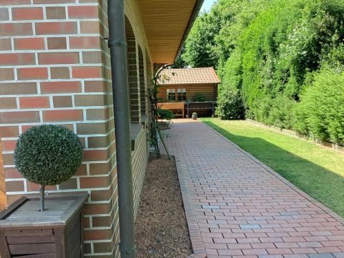 a house with a brick walkway next to a building at Landhaus Saterland Ferienwohnung NEU Emsland Ostfriesland Nordsee in Sedelsberg
