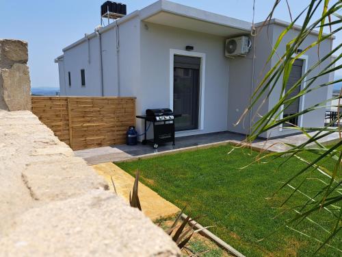 a white house with a grill in a yard at Christine luxury villa in Kolymvari