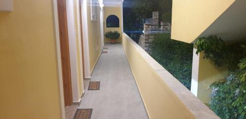 a hallway of a house with yellow walls and plants at Apart-Hotel Llazari in Himare