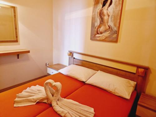 sypialnia z pomarańczowym łóżkiem i ręcznikiem w obiekcie Guest House Sombrero w mieście Senj