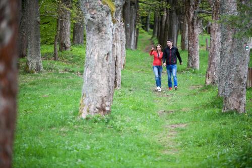 a man and woman walking down a forest trail at Grund Resort Golf and Ski in Mladé Buky
