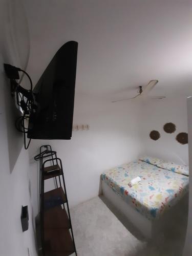 a room with a bed and a tv and a ladder at Rivera Hostel in Santa Marta