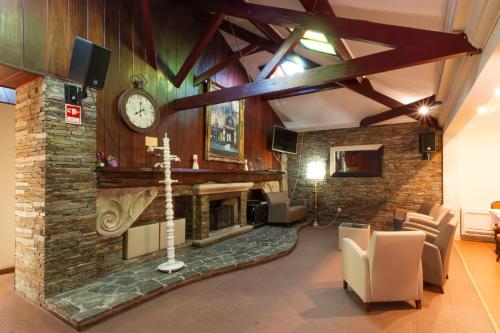 a living room with a fireplace and a clock on a wall at Hotel Joao Padeiro in Aveiro