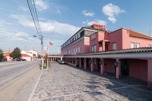 uma rua numa cidade com um edifício cor-de-rosa em Hotel Joao Padeiro em Aveiro