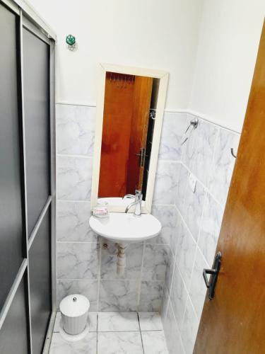 a bathroom with a sink and a mirror at 2 quartos com ar - Apto em condomínio in Campo Grande