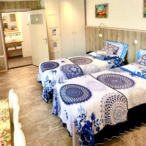 twee bedden in een kamer met blauwe en witte dekens bij Rooi Bij de Knoptoren B&B in Sint-Oedenrode