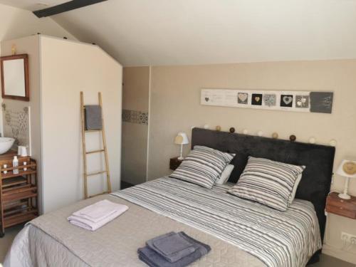 a bedroom with a bed with two towels on it at Chambres d'hôtes L'Escale Charmante in Choussy