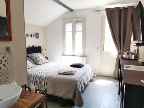 een slaapkamer met een bed, een wastafel en een bad bij Chambres d'hôtes L'Escale Charmante in Choussy