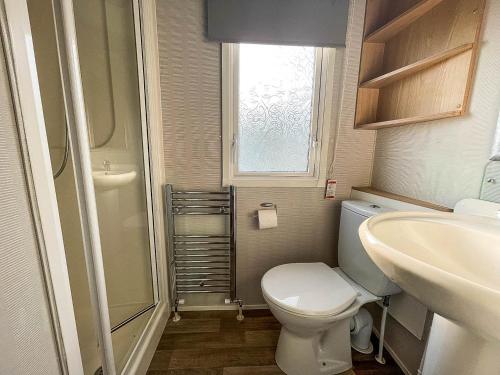 a small bathroom with a toilet and a sink at Lovely 8 Berth Caravan Nearby Scratby Beach In Norfolk Ref 50021f in Great Yarmouth