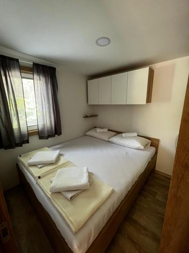 ein Schlafzimmer mit einem großen Bett mit zwei Handtüchern darauf in der Unterkunft Lily C in Pakoštane