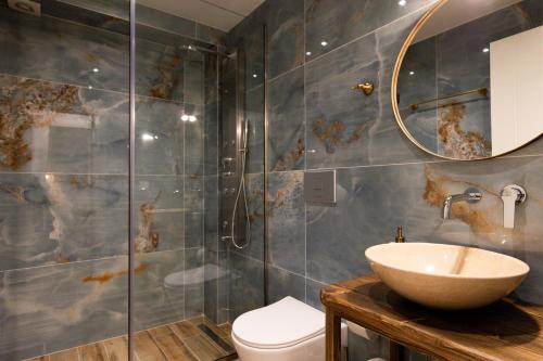 a bathroom with a toilet and a sink and a shower at Villa Nous luxury in Skala Sotiros