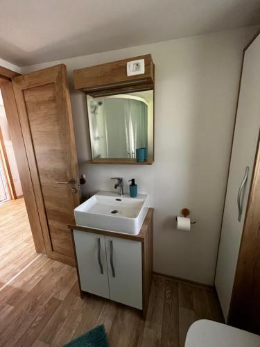 ein Badezimmer mit einem weißen Waschbecken und einem Spiegel in der Unterkunft Lily C in Pakoštane