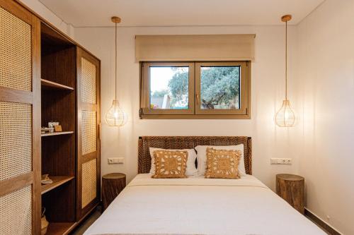 a bedroom with a bed with two pillows and a window at Villa Nous luxury in Skala Sotiros
