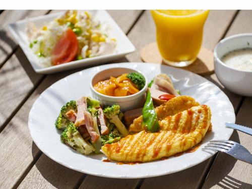 a plate of food with corn and vegetables and a drink at Yenns Marina Inn Mercy in Ginowan