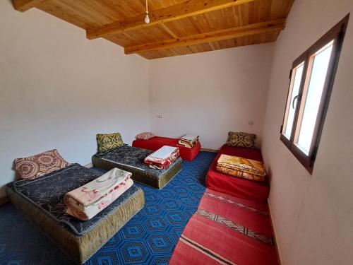 una sala de estar con 2 sofás y una ventana en Gite taouraout, en Midelt