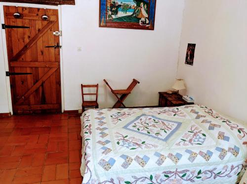 ein Schlafzimmer mit einem Bett mit einer Decke darauf in der Unterkunft chambre d'hôte La Fontaine in Saint-Michel-Lapujade