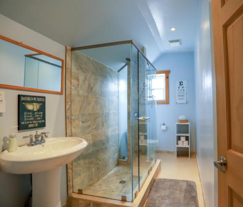 a bathroom with a glass shower and a sink at 23Maple in Haliburton