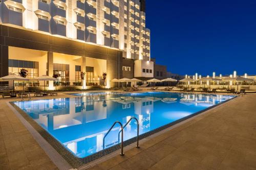 a large swimming pool in front of a hotel at Wyndham Bukhara in Bukhara