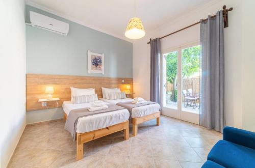 a bedroom with two beds and a blue couch at EVI - FAMILY APARTMENTS in Kavos