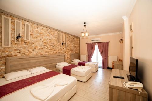 a hotel room with two beds and a television at Kuzey Park Hotel in Gokceada Town