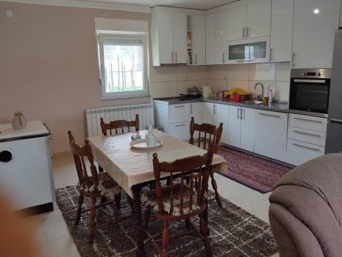 a kitchen with a table and chairs in a room at Apartman Dakovic in Zlatište
