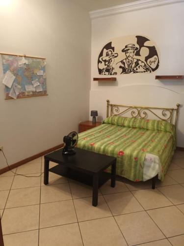 Un dormitorio con una cama y una mesa. en Casa Augusto, en Vetralla